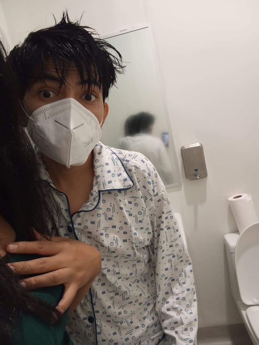 Joseph con pijama de hospital y mascarilla, abrazado por un familiar