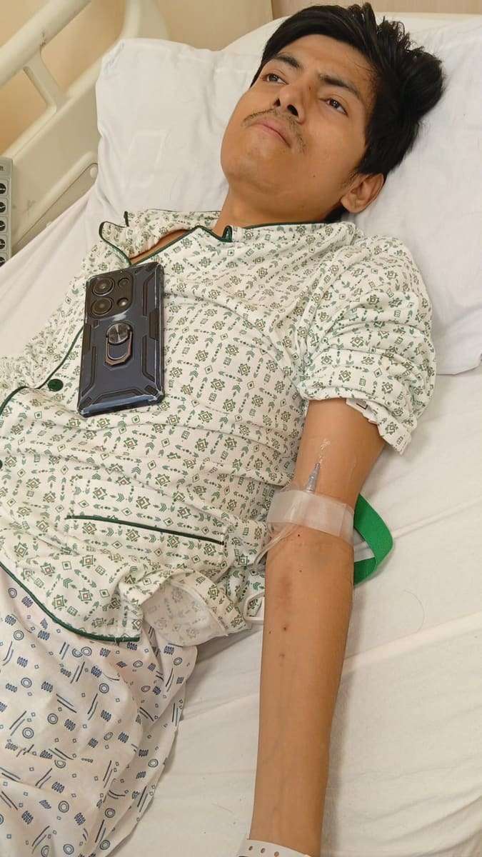 Joseph recostado con una vía en el brazo en la cama del hospital