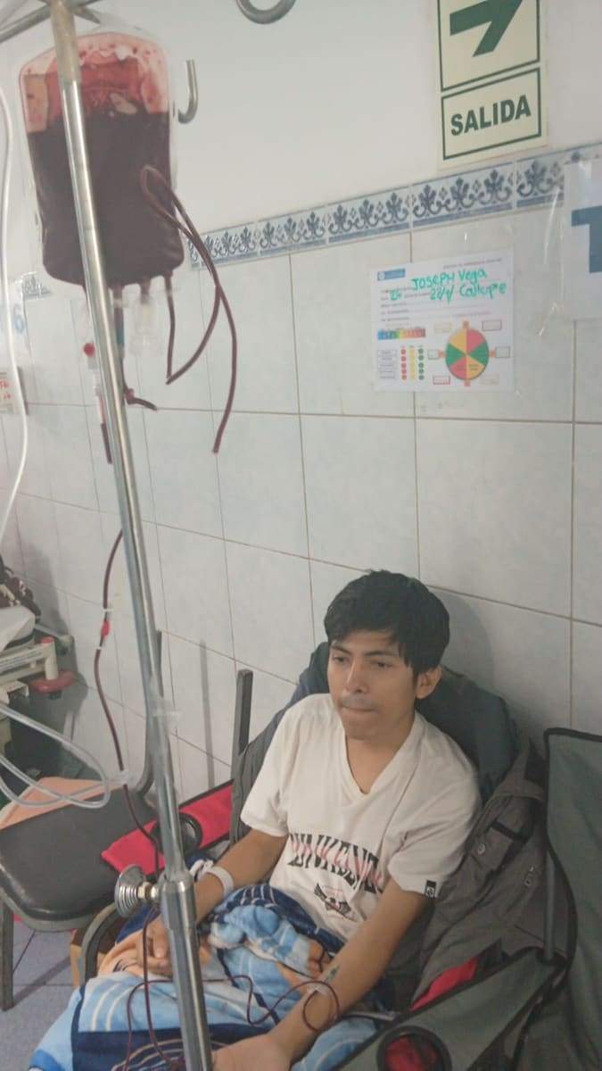Joseph sentado junto a una bolsa de transfusión de sangre en el pasadizo de emergencia
