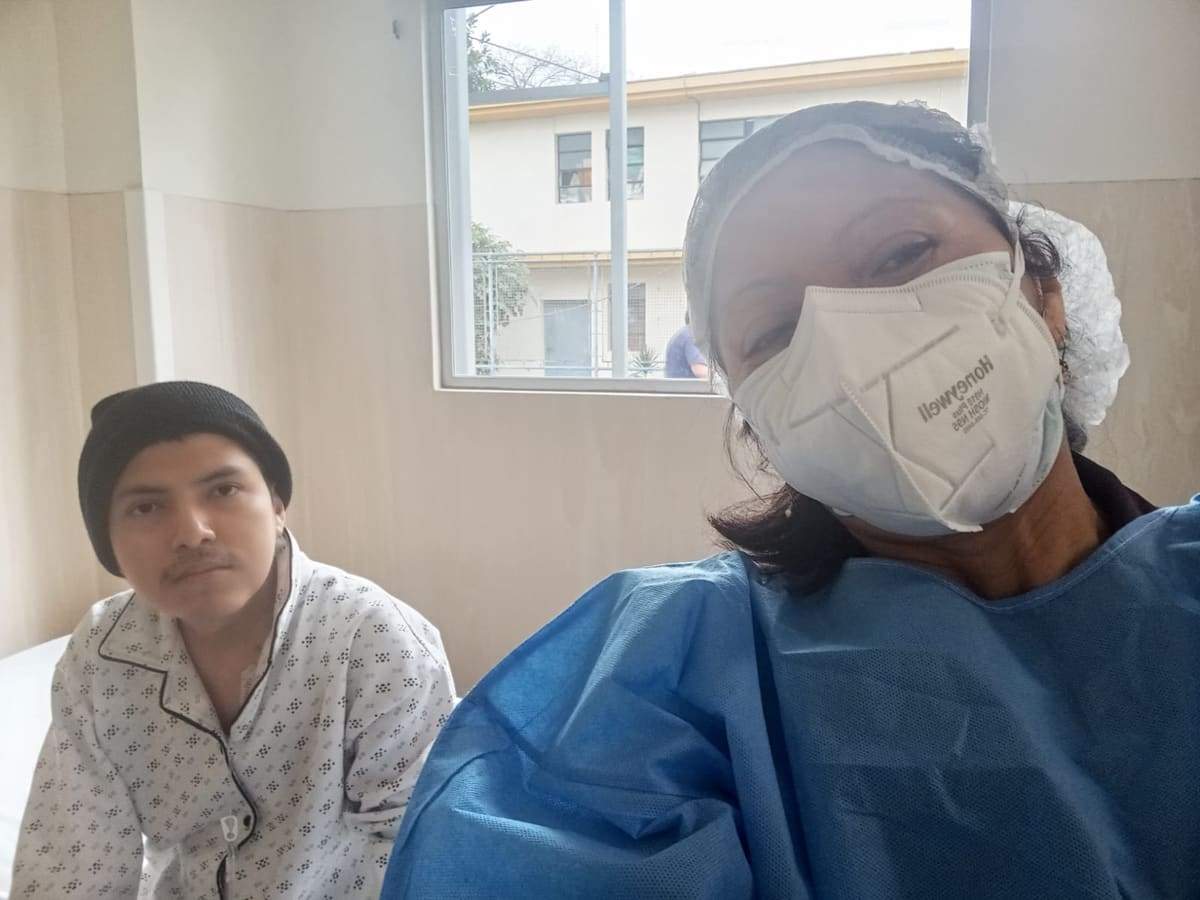 Joseph con gorro junto a su mamá, que lleva el traje de aislamiento para cuidarlo