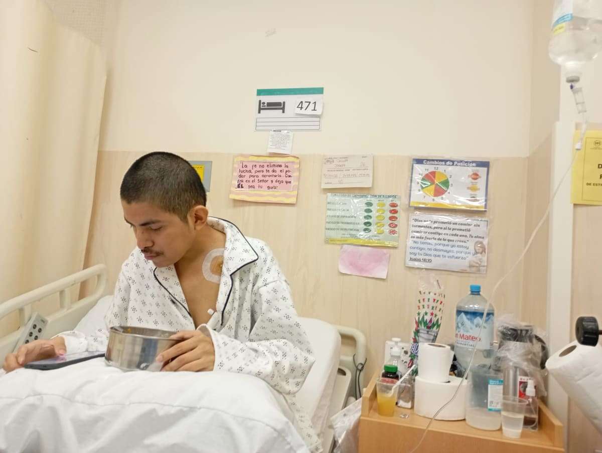 Joseph rapado leyendo sentado en su cama de hospital