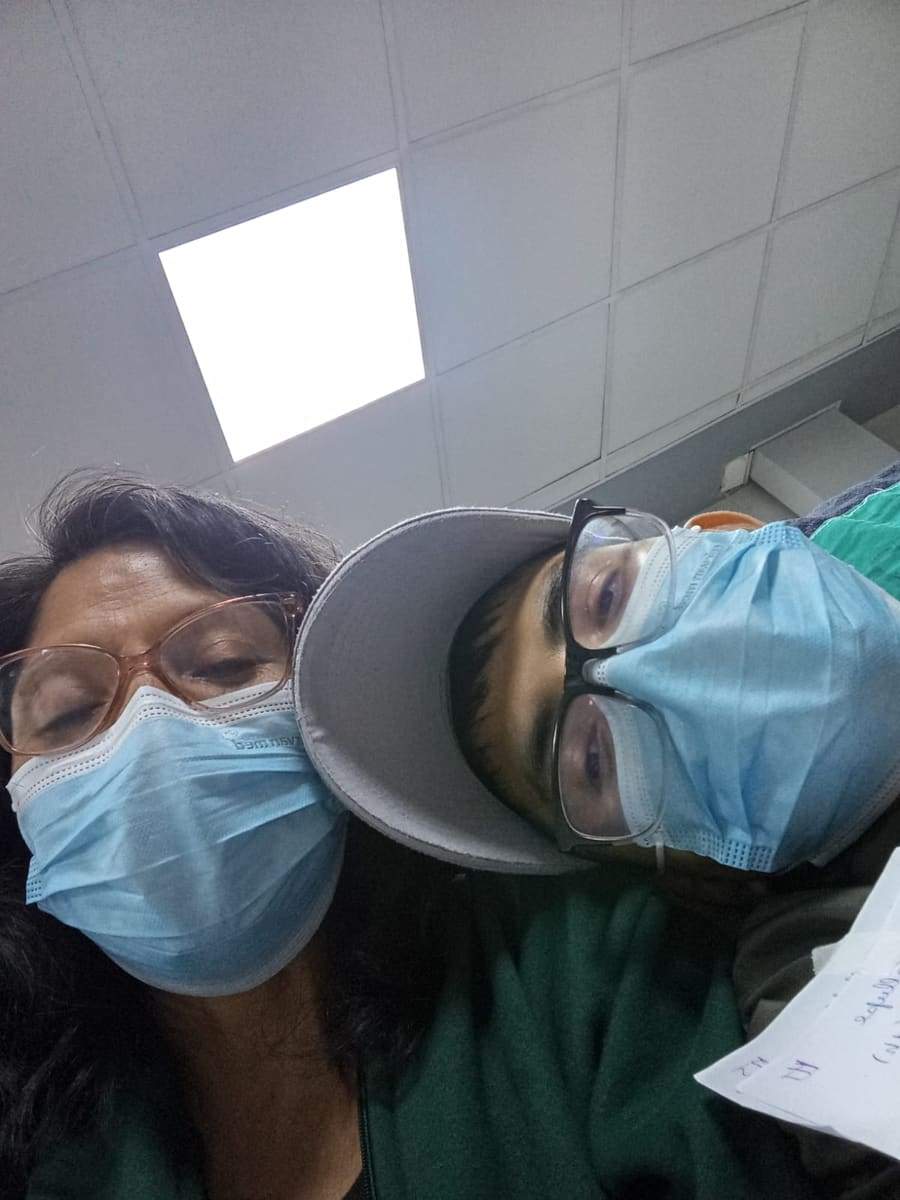 Joseph con gorro y mascarilla junto a su mamá, que también lleva mascarilla, en el hospital
