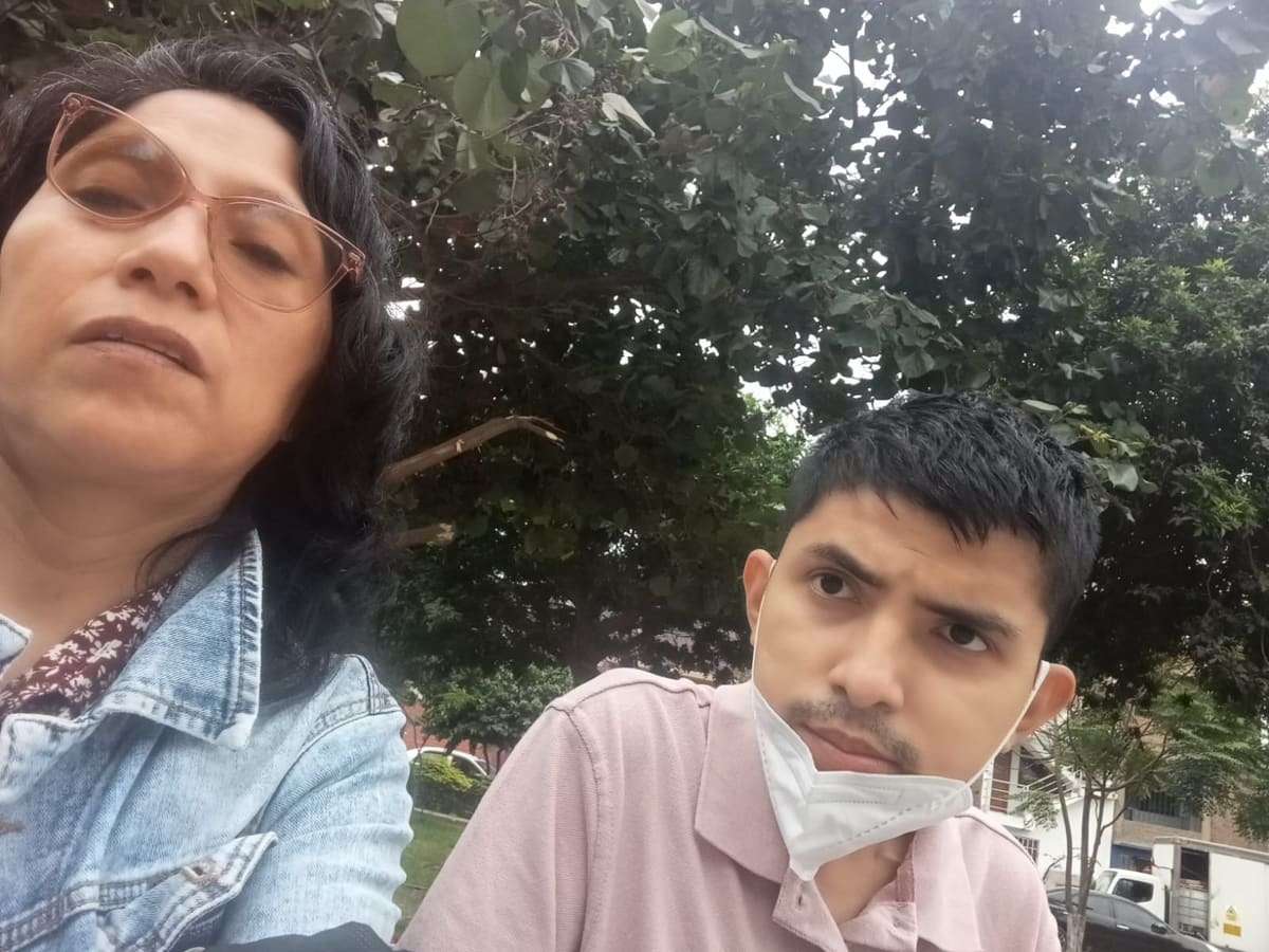 Joseph y su mamá tomándose un selfie bajo los árboles de un parque